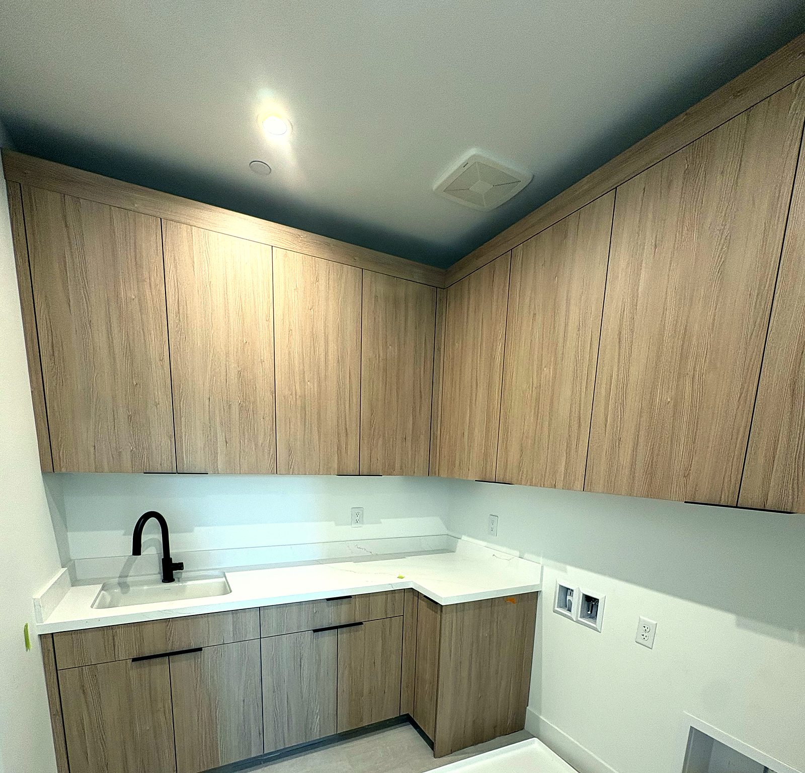L-shaped oak laundry cabinets